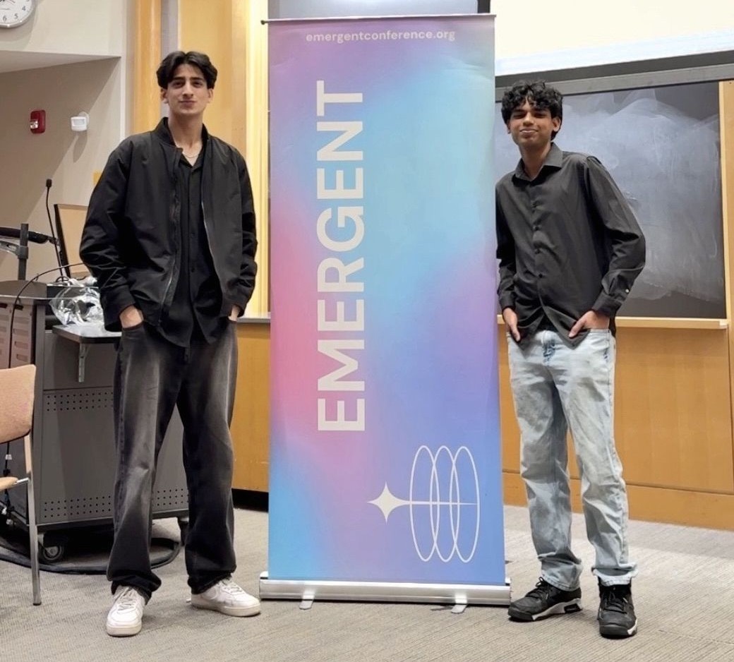 Arsh Hashmi and Ishmael Lallmahamad standing in front of Emergent signage at Brown University
