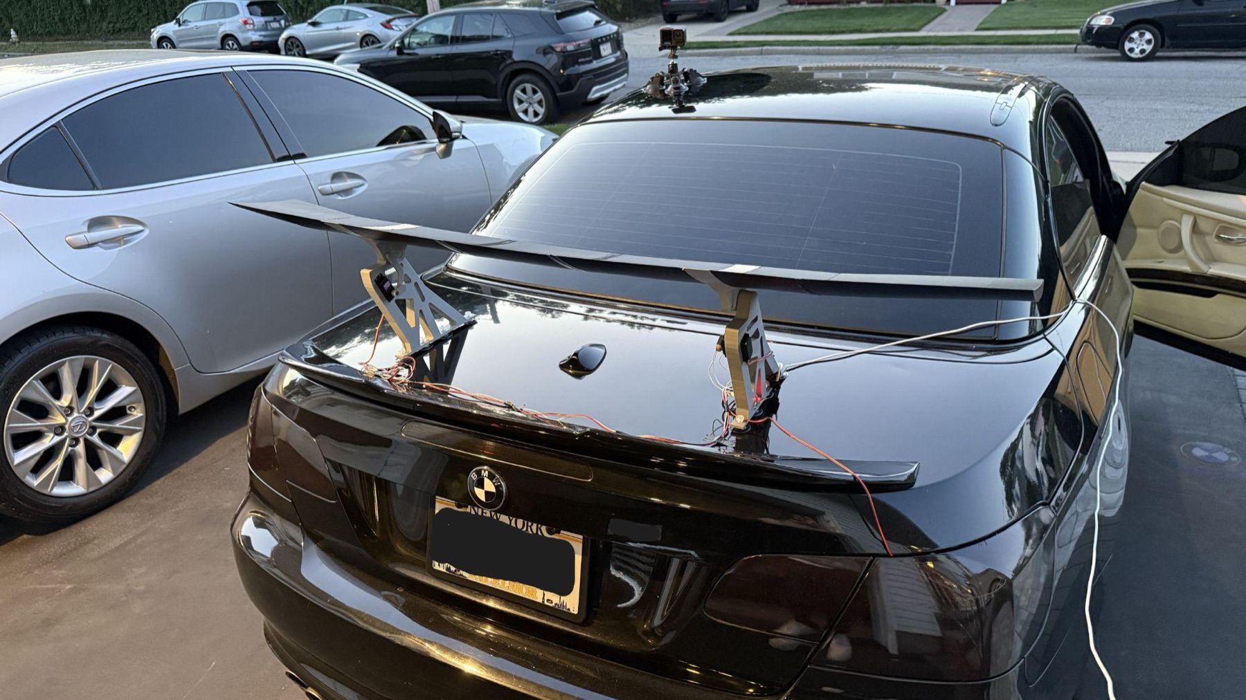 The finished wing mounted on the trunk lid of a black BMW E93, seen from behind